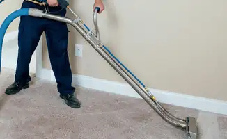 Professional operating a liquid removal machine on a carpeted floor in Stockton, CA
